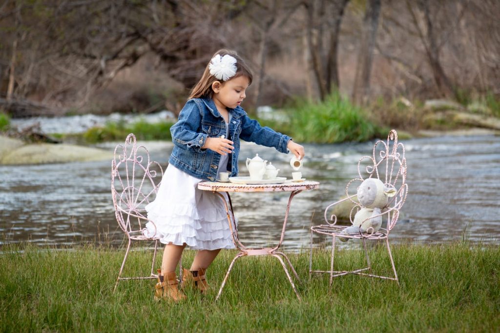 Niña jugando en el campo con osito